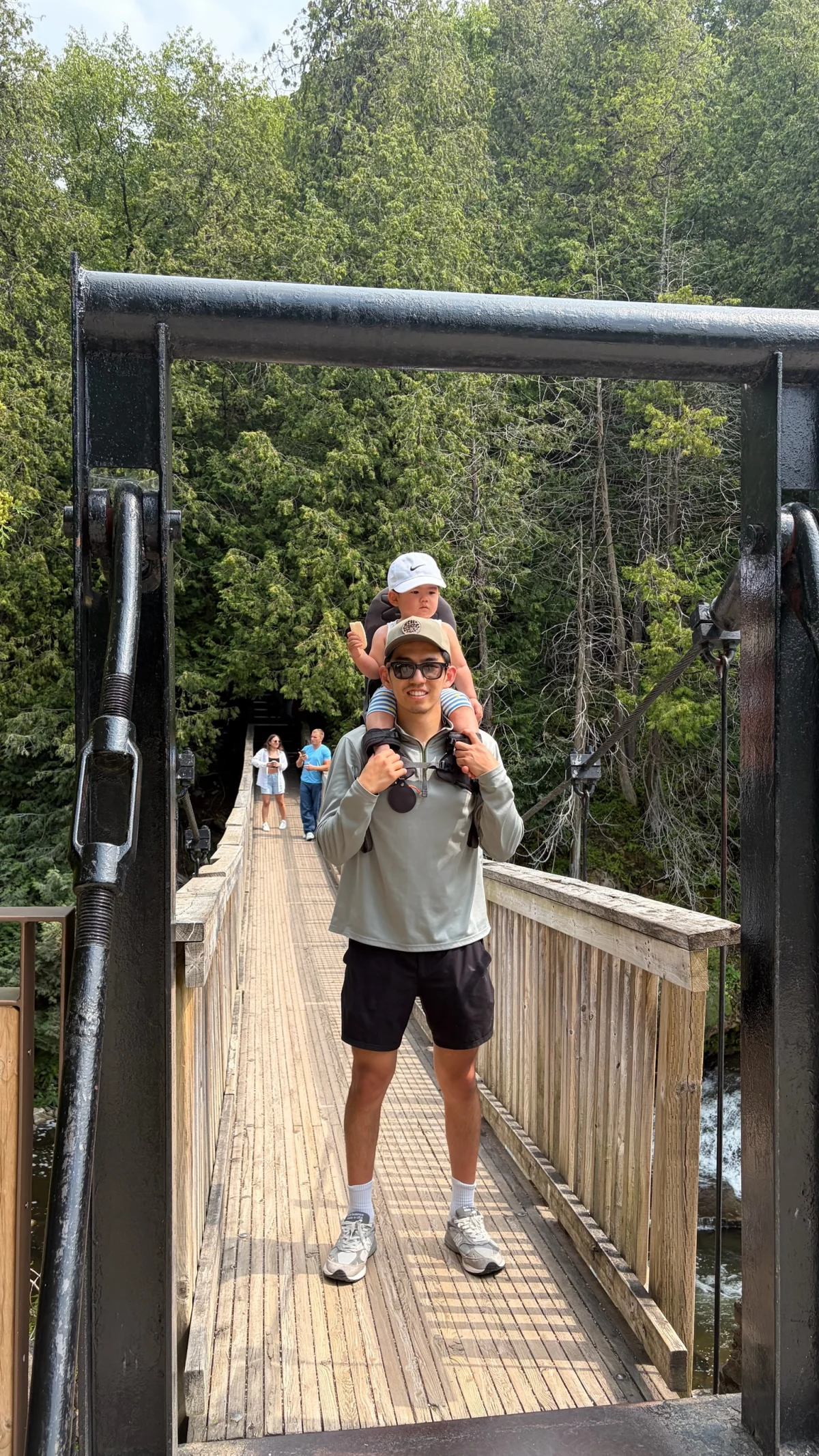 Anzhe and his son on a forest bridge